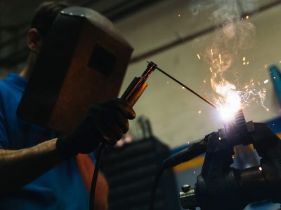 Professional Mechanic welding in Garage.