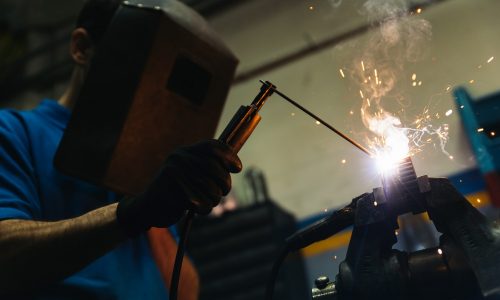 Professional Mechanic welding in Garage.
